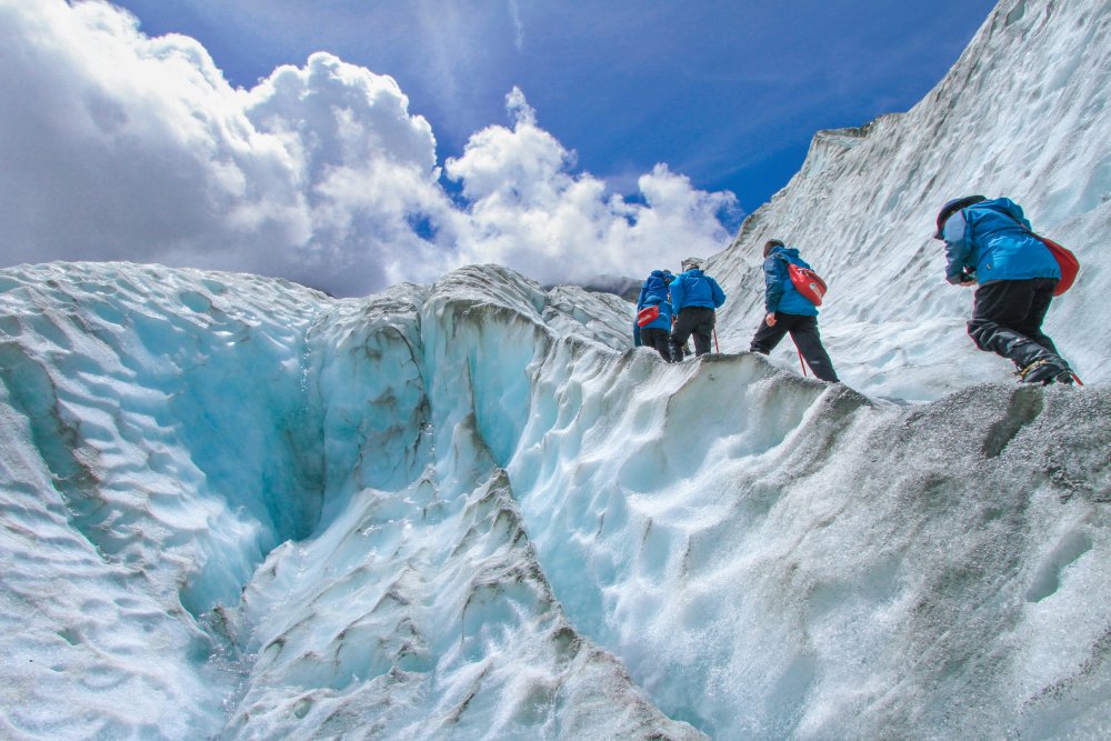 Mountaineer standing triumphantly at mountain summit with panoramic landscape view